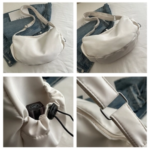 Detailed close-up of white nylon dumpling bag with silver hardware and drawstring details