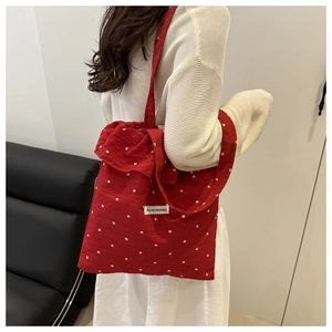 Détail du sac cabas rouge à fleurs avec volants et étiquette de marque AGOGO ORIGINAL