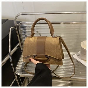 Detail view of vintage canvas handbag with leather strap and metal stand display
