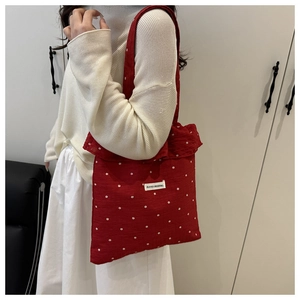 Détail du sac cabas rouge à fleurs avec étiquette ADOGO ORIGINAL et volants
