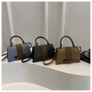 Three minimalist small square shoulder bags in denim blue, charcoal grey, and khaki brown