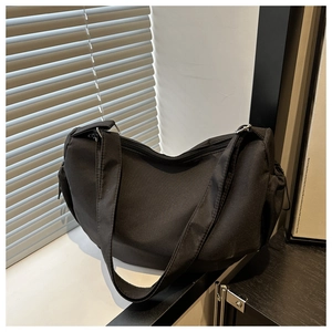 Detail view of durable black nylon crescent bag with wide shoulder strap and zip closure
