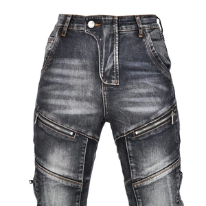 Detail of motorcycle jeans featuring dual metal zippers and vintage washed denim texture