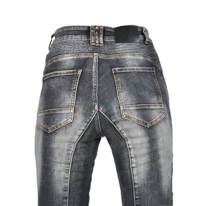Close-up of vintage grey riding jeans featuring elastic accordion panels and orange stitching