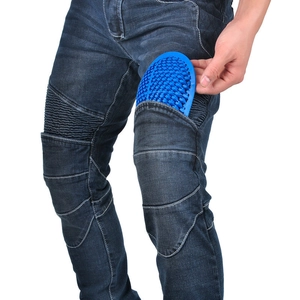 Detail showing blue honeycomb motorcycle knee protector being inserted into denim riding pants
