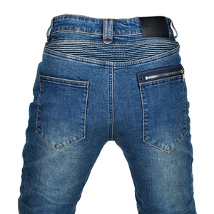Detail view of motorcycle jeans featuring biker style waist pleats and leather brand patch