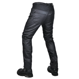 Details von gewachsten Motorradjeans mit elastischen Akkordeon-Panels und Stiefeln