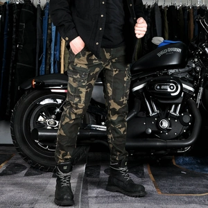 Detail of dark green camouflage cargo motorcycle pants with multi-pocket design on side