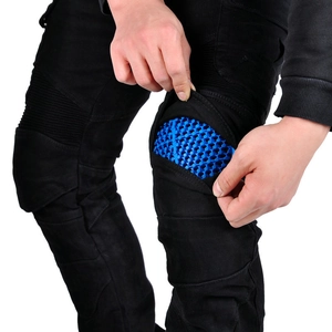 Detail of blue honeycomb knee pads inside black motorcycle riding jeans for protection