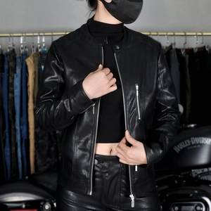 Close-up of women's black leather biker jacket featuring metallic zippers and sleek stand collar