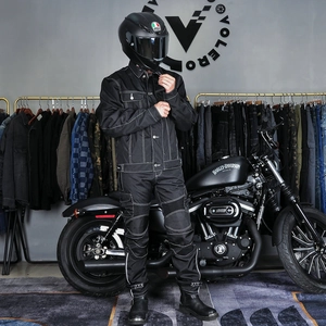 Détail de la tenue de moto noire avec coutures contrastées blanches et poches cargo