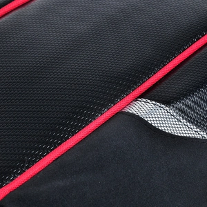 Detail of waterproof motorcycle tail bag with carbon fiber texture and red piping accents