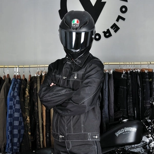 Détail de la veste de moto noire avec surpiqûres contrastées dans un studio de biker