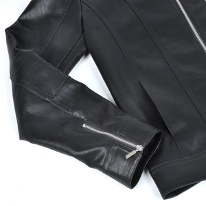 Detail shot of black motorcycle jacket sleeve with silver metal zipper and leather texture
