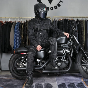 Détail d'une combinaison de moto noire avec surpiqûres contrastées blanches et tissu durable