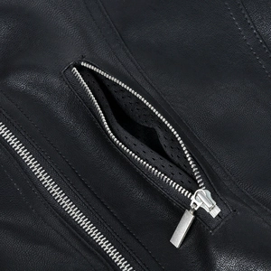 Detail of black pebbled leather texture and silver zippers on a motorcycle jacket