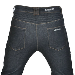 Detail view of denim motorcycle pants featuring accordion stretch panels and brand embroidery