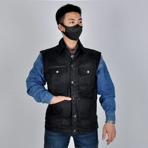 Détail d'un gilet de moto en toile cirée vintage avec boutons en métal et poches poitrine