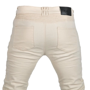 Détail du jean motard crème avec empiècements extensibles et écusson de taille en cuir