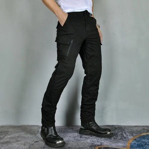 Detail of black motorcycle cargo pants featuring functional side pockets and reinforced seams