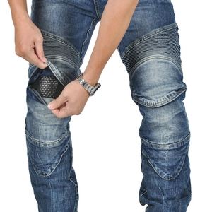 Close-up of motorcycle jeans featuring protective honeycomb knee pads and pleated fabric
