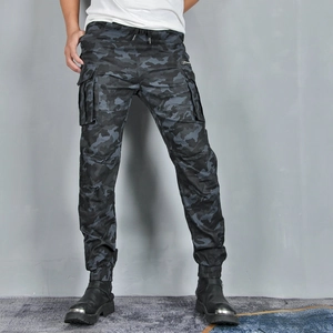 Détail du pantalon cargo camouflage avec de grandes poches latérales et détails zippés