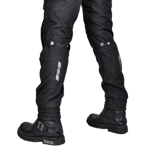 Detail view of motorcycle riding pants featuring reflective strips and adjustable leg straps