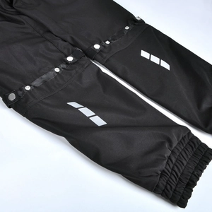 Detail of motorcycle pants showing silver reflective strips and metal adjustment buttons