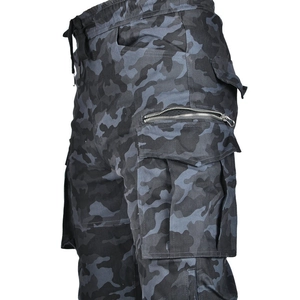 Détail macro du pantalon cargo moto camouflage montrant fermetures et texture du tissu