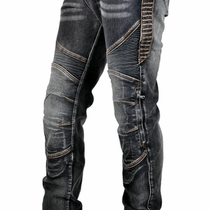 Détail de jean moto avec panneaux de genoux côtelés et surpiqûres orange contrastées