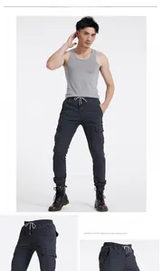 Detail view of charcoal cargo pants featuring drawstring waist and large flap side pockets