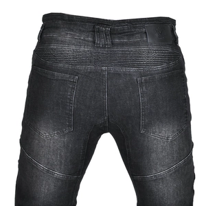 Details der elastischen Akkordeonfalten an Motorradjeans mit Leder-Logo-Patch