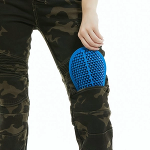 Detail of blue honeycomb silicone knee pad being inserted into camo motorcycle pants