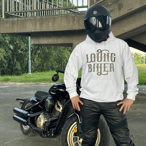 Motorcycle rider wearing white hoodie and protective biker pants with knee padding detail