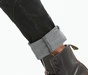 Detailansicht von schwarzer Stretch-Jeans kombiniert mit klassischen Lederstiefeln
