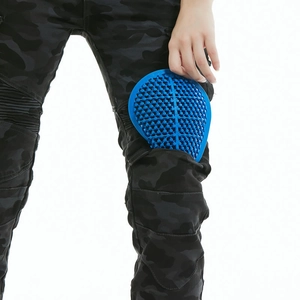 Detail view of blue honeycomb knee protectors on black camo motorcycle pants