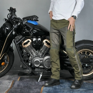 Army green mesh motorcycle riding jeans with protective pads next to a cruiser bike