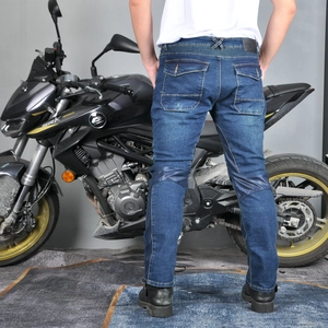 Détail du jean moto bleu avec plis de protection aux genoux et étiquette de taille