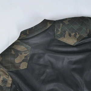 Détail de la maille noire respirante et des empiècements matelassés camouflage sur la veste