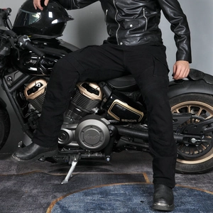 Detail of black motorcycle cargo pants showing side pockets and flexible knee accordion panels