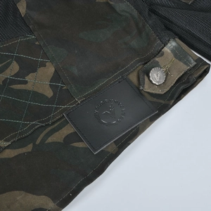 Détail macro de la veste moto camouflage avec patch cuir logo et tissu maille respirant