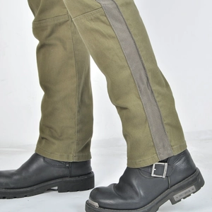 Detail shot of army green motorcycle jeans paired with black leather biker boots