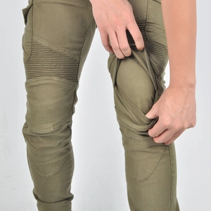 Detail showing the elastic accordion pleats on the knee of green motorcycle riding jeans