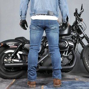 Rear view of slim fit blue motorcycle jeans for men next to a black cruiser bike