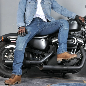 Men's blue motorcycle jeans with reinforced knees shown in a professional riding scene