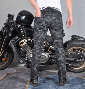 Rear view of camo motorcycle riding pants with cargo pockets against a cruiser bike