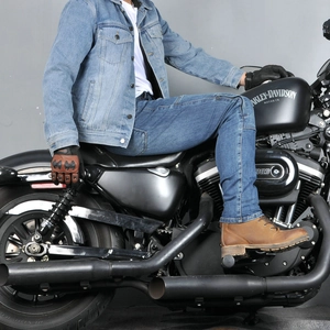 Close-up of vintage blue motorcycle denim suit worn by a rider on a classic motorbike