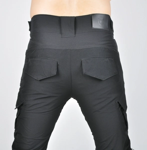 Detail view of motorcycle pants featuring tactical rear pockets and leather logo patch
