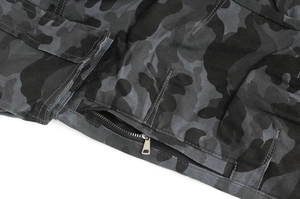 Detail of metal zipper and double-stitched seams on grey camouflage motorcycle pants