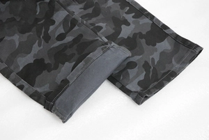 Macro detail of camouflage motorcycle pants cuff with double-stitched hem and grey lining